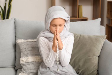 Little Muslim girl praying at home
