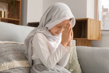 Little Muslim girl praying at home