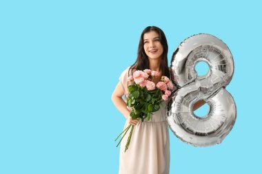 Gümüş renkli hava balonu olan güzel bir kadın ve mavi arka planda bir buket pembe gül. Uluslararası Kadınlar Günü