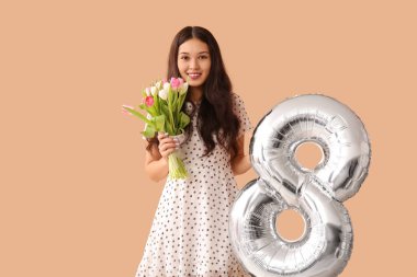 Gümüş renkli hava balonu olan güzel bir Asyalı kadın figür 8 ve kahverengi arka planda bir buket güzel lale. Uluslararası Kadınlar Günü