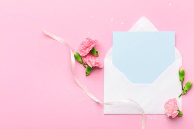 Zarflı güzel karanfiller ve pembe arka planda boş bir kart. Uluslararası Kadınlar Günü kutlamaları
