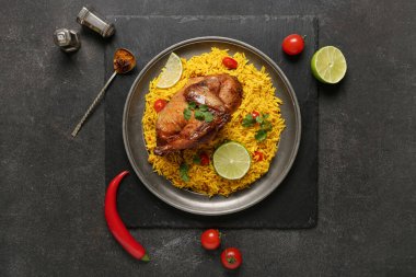 Siyah arka planda malzemelerle geleneksel tavuk biryani tabağı.