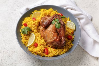 Beyaz masada bir kase geleneksel tavuk biryani.