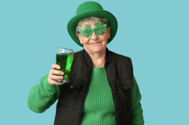 Leprikon şapkalı yaşlı bir kadın ve mavi arka planda bir bardak birayla dekoratif bardaklar. Aziz Patrick Günü kutlaması