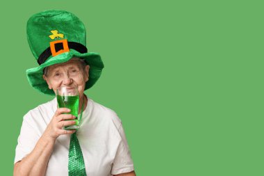 Yeşil arka planda bir bardak birayla cüce şapkalı yaşlı kadın. Aziz Patrick Günü kutlaması