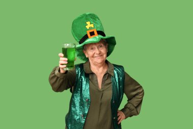 Yeşil arka planda bir bardak birayla cüce şapkalı yaşlı kadın. Aziz Patrick Günü kutlaması