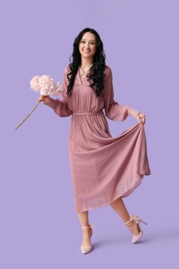 Leylak arka planında ortanca çiçekleri olan güzel bir genç kadın. Uluslararası Kadınlar Günü