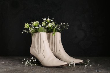 Siyah arka planda çiçekli bej çizmeler