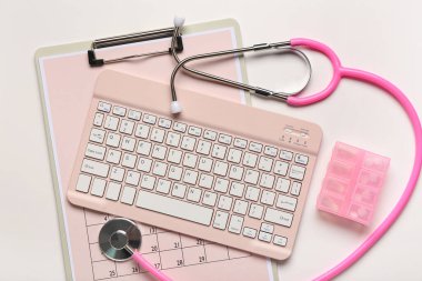 Beyaz arkaplanda pano, bilgisayar klavyesi, haplar ve steteskop