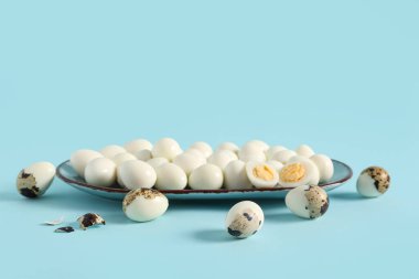 Mavi arka planda taze kaynamış bıldırcın yumurtalı tabak.