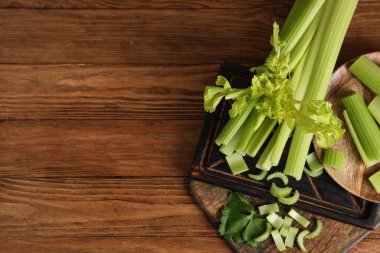 Ahşap zemin üzerinde taze yeşil kereviz olan tahtalar ve tabaklar.