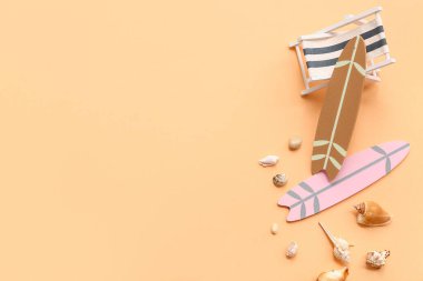 Güverte sandalyesi, sörf tahtaları ve bej arka planda deniz kabukları. Yaz konsepti