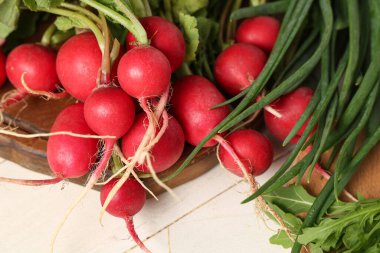 Tahtayı taze turpla kesmek ve açık ahşap masada otlar, yakın plan.