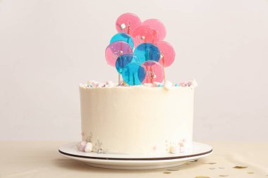 Beyaz duvara karşı masada doğum günü partisi için pasta.