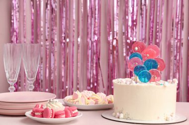 Doğum günü partisi için masada pembe süslemeli kek.