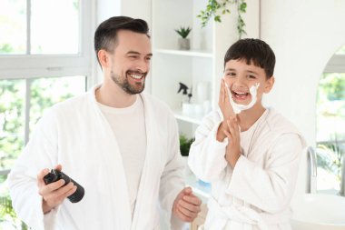 Mutlu baba ve küçük oğlu banyoda tıraş köpüğü sürüyorlar.