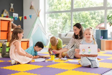 Anaokulunda resim çizen sevimli küçük kız.