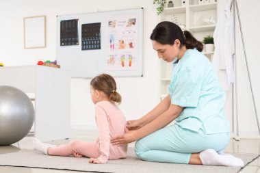 Biraz hasta esneme ve klinikte egzersiz yapan kadın osteopat.