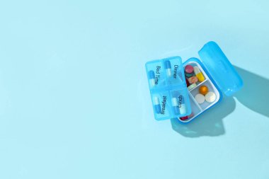 İlaç organizatörleri mavi arka planda. Üst görünüm