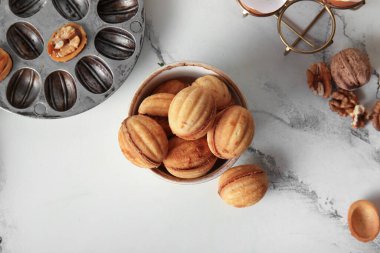 Bir kase tatlı ceviz şekilli kurabiye ve hafif arka planda kaynamış konsantre süt.