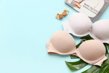 Tarz sahibi bayan sütyenler, küpeler ve arka planda palmiye yaprağı.