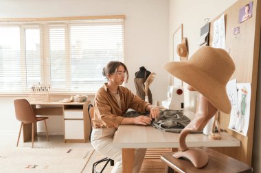 Atölyesinde çalışan genç bayan terzi.