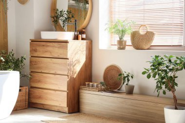 Lavabosu, küveti, çekmecesi ve aynası olan şık bir banyo.