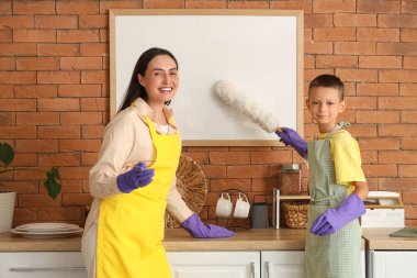 Anne ve oğlu evde boş çerçeveyi birlikte temizliyorlar.