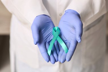 Klinikte kurdeleli olgun bir kadın doktor, yakın plan. Rahim Sağlığı Bilinci Ayı