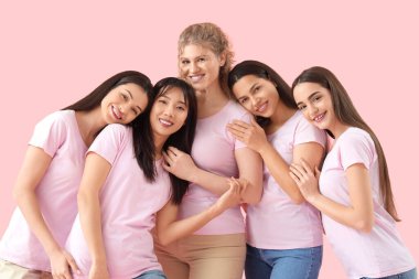 Pembe arka planda sarılan bir grup genç kadın.