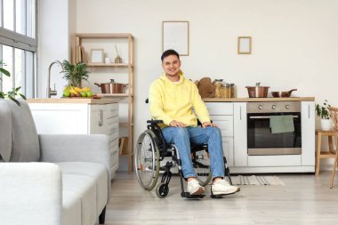 Evdeki tekerlekli sandalyedeki yakışıklı genç adam.