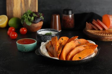 Pişmiş patates ve siyah grunge soslu fırın yemeği.