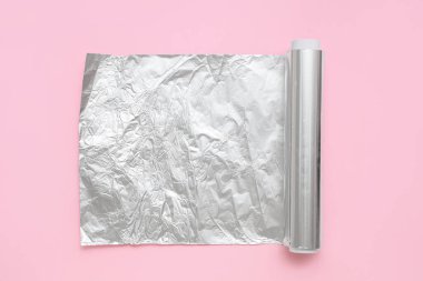 Pembe arkaplanda alüminyum folyo rulo