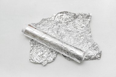 Alüminyum folyo rulo beyaz zemin üzerinde buruşmuş çarşaf