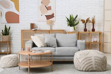 Rahat bir kanepe, kahve masası ve oturma odasının içi puf puf dolu.