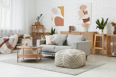 Rahat bir kanepe, kahve masası ve oturma odasının içi puf puf dolu.