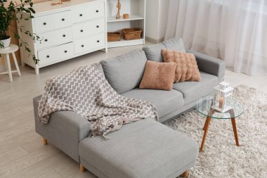 Oturma odasının içinde fener olan rahat bir kanepe ve kahve masası.