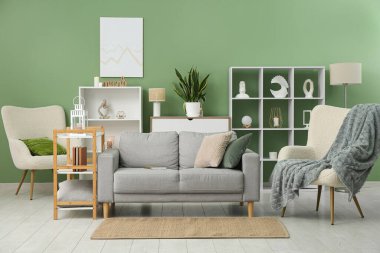 Oturma odasının içinde rahat bir kanepe, koltuk ve raf var.