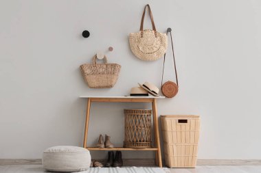 Salonun içinde sepet, sepet, puf ve hasır çantalar var.