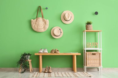 Koridorun iç tarafındaki bankta ayakkabılar ve raf ünitesi var.