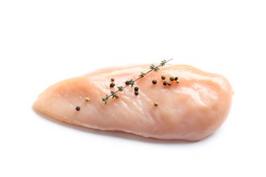 Çiğ tavuk göğsü kekik ve beyaz arka planda karabiber.