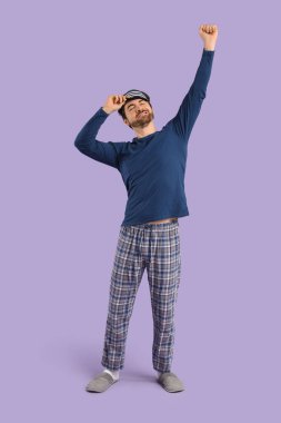 Maskeli yakışıklı genç adam leylak arka planda geriniyor.