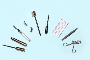 Mavi arkaplanda maskara ve araçlarla farklı takma kirpikler