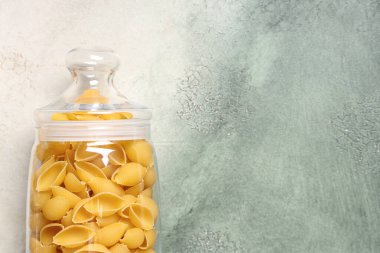 Grunge arka planında çiğ konchiglie makarna ile kavanoz