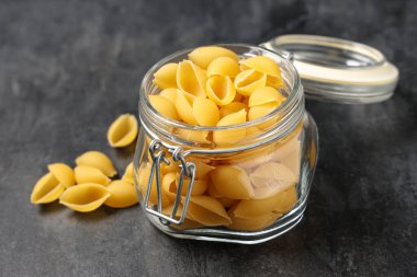 Siyah zemin üzerinde çiğ koni makarnası olan kavanoz