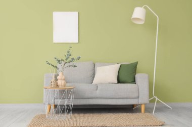 Rahat bir kanepe ve okaliptüs dalları olan bir sehpa.