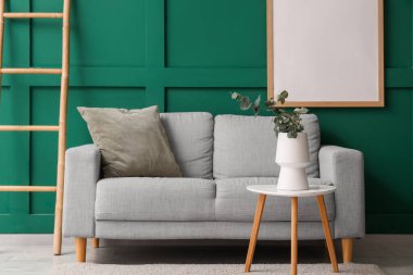 Merdiven, rahat bir kanepe ve okaliptüs dalları olan bir sehpa.