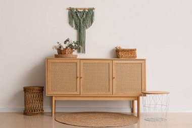 Okaliptüs dalları olan çekmeceler beyaz duvarın yanında, odada.