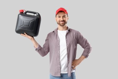 Gri arka planda teneke kutusu olan genç adam.