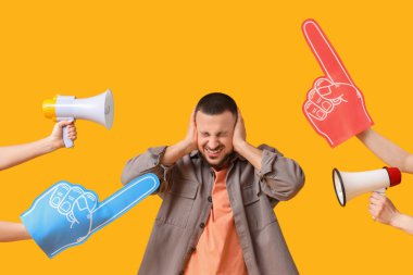 Young man suffering from loud noise and foam hands with megaphones on yellow background clipart